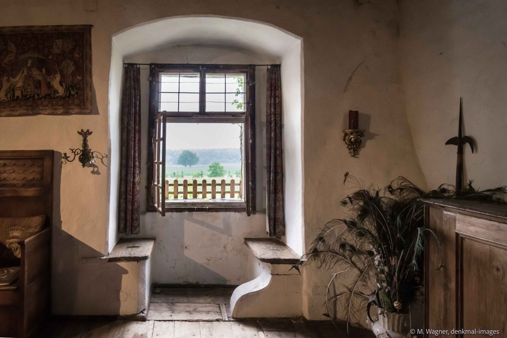 Fensternische in einer Schlossmauer mit Sitzbaenken und Ausblick ueber Wiesen - Denkmalfotografie