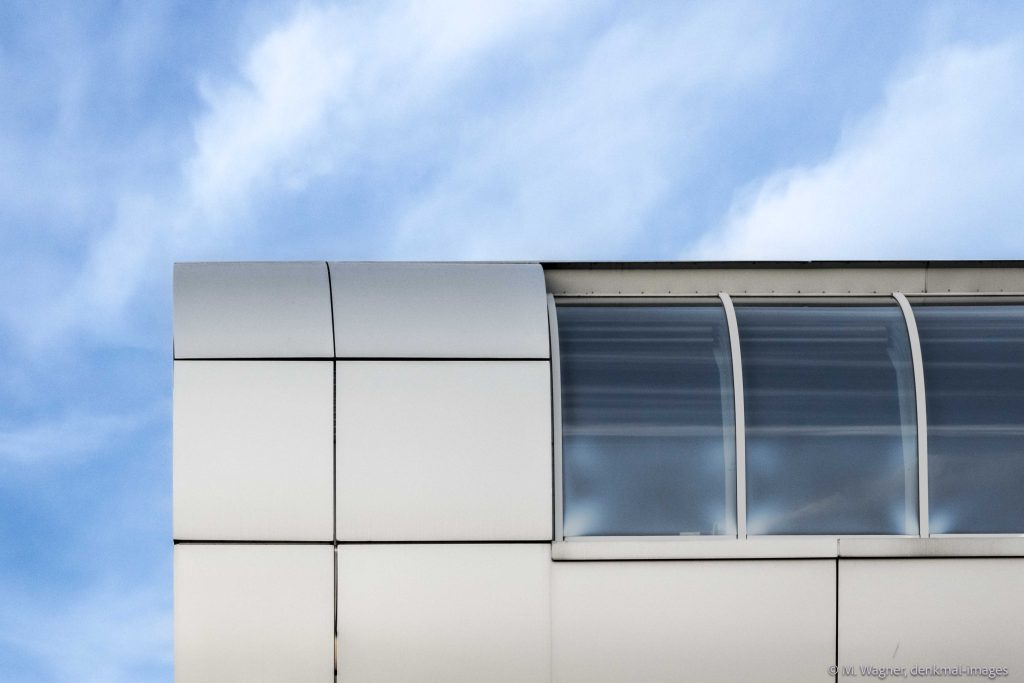 silberne Fassade mit Fenstern Hotel Kameha vor bewoelktem Himmel, Architekturfotografie